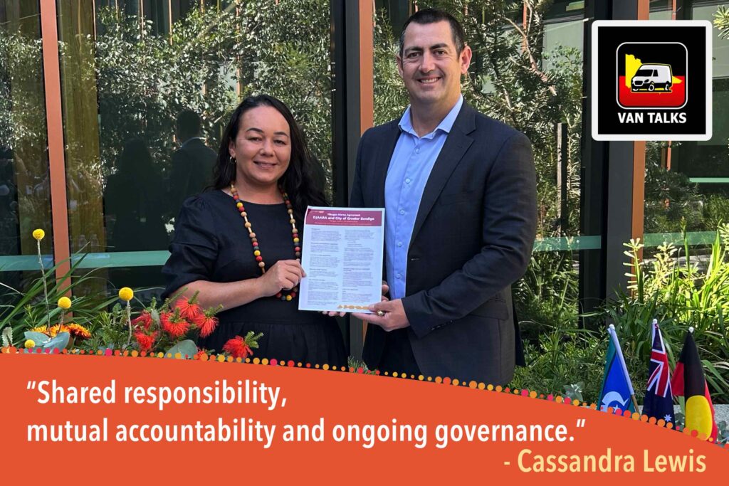 Cassie and Andrew Cassandra Lewis, on the left, wears a black dress and a colourful beaded necklace. Andrew Cooney, on the right, wears a grey suit jacket and a light blue shirt. In the bottom right, three small flags (Torres Strait Islander, Australian, and Aboriginal) are displayed. The image includes a "VAN TALKS" logo in the top right and a quote at the bottom: "Shared responsibility, mutual accountability and ongoing governance. - Cassandra Lewis."